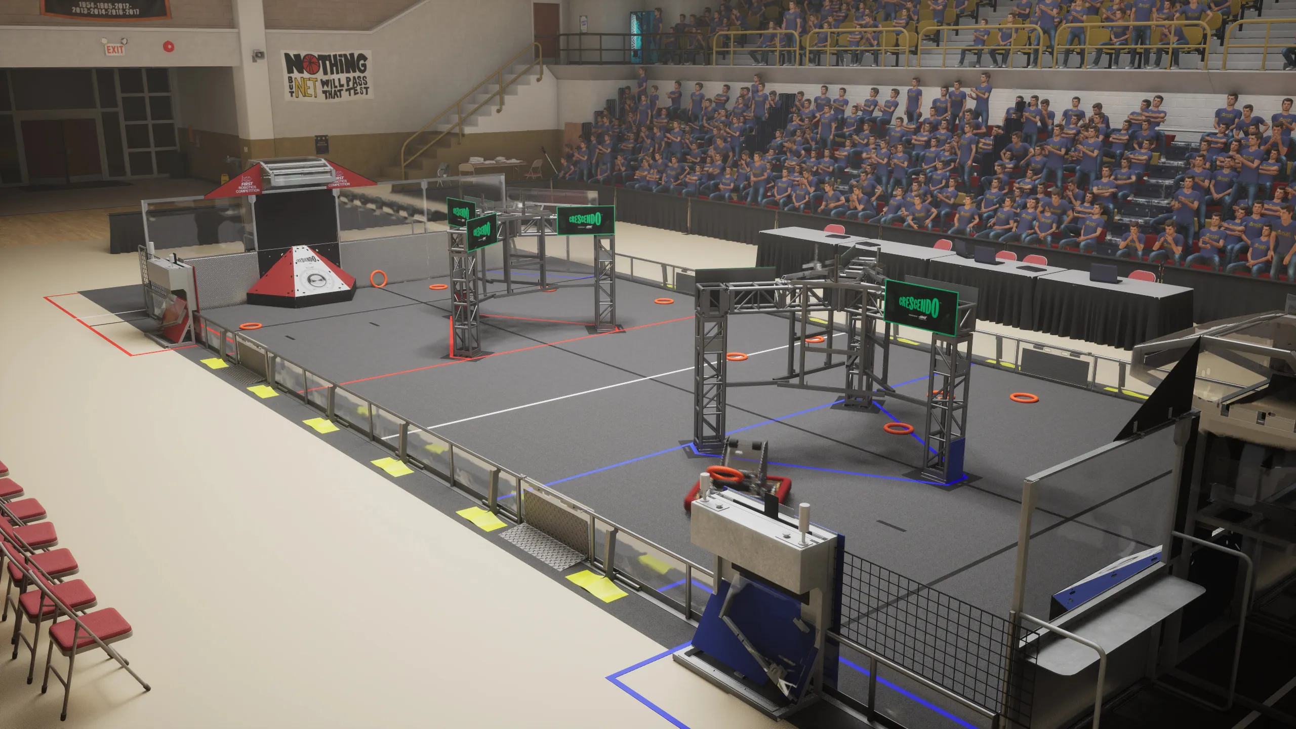 The competition field set up in a high school gym with full stands.